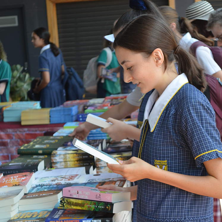 Year 10 ILC Student choosing books to read at Voice on the Coast Writers Festival